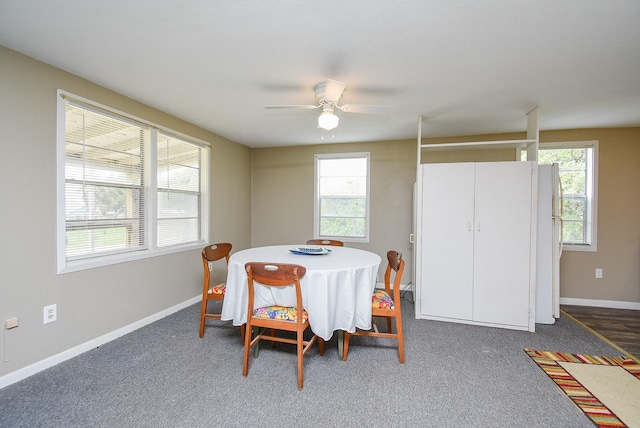 carpeted dining space with baseboards and a ceiling fan