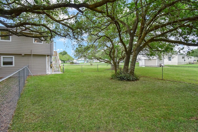view of yard featuring a fenced backyard and stairs