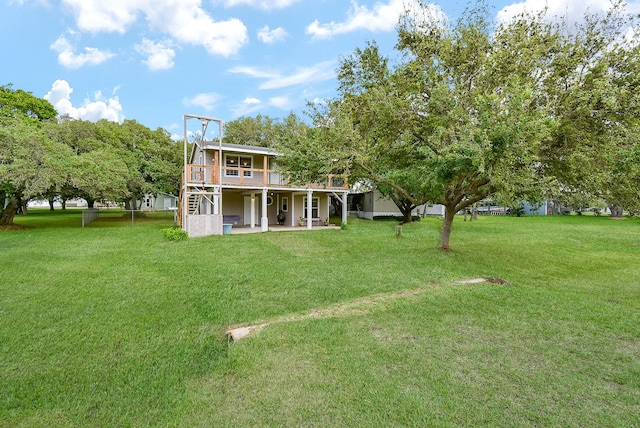 rear view of property with stairs, a patio area, a wooden deck, and a yard
