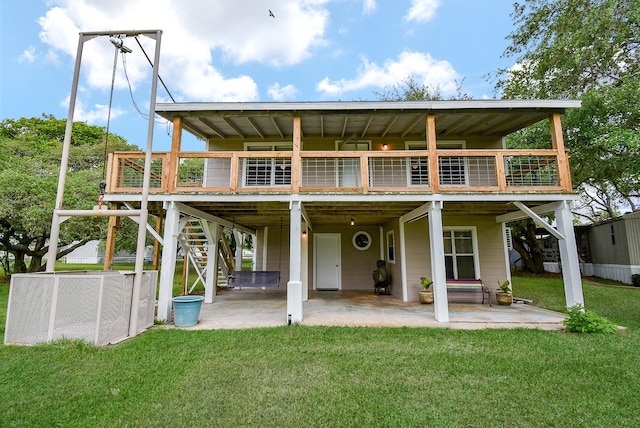 rear view of house with a wooden deck, stairway, a patio area, a lawn, and a carport