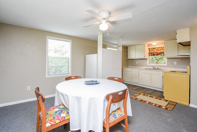 dining space with baseboards, a ceiling fan, and dark carpet