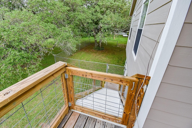 wooden deck with a lawn and a fenced backyard