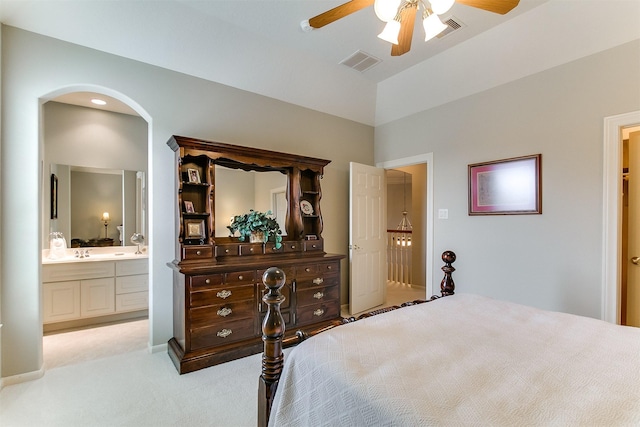 bedroom with visible vents, carpet flooring, arched walkways, and ensuite bathroom