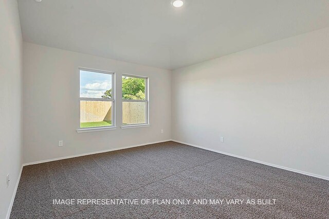 empty room featuring baseboards and dark colored carpet