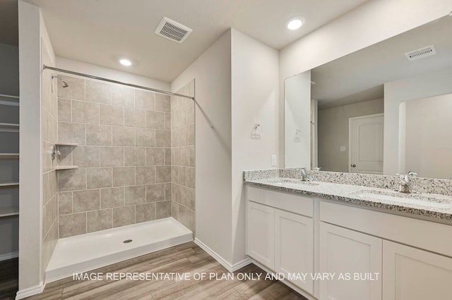 full bath with visible vents, a sink, and wood finished floors