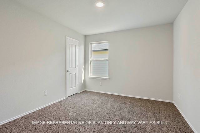 carpeted empty room featuring baseboards