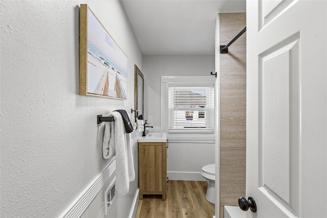 bathroom featuring toilet, wood finished floors, and vanity