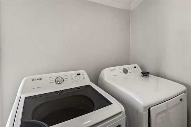 clothes washing area featuring washing machine and clothes dryer and laundry area