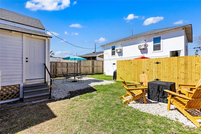 view of yard featuring a fenced backyard, a fire pit, and a patio area