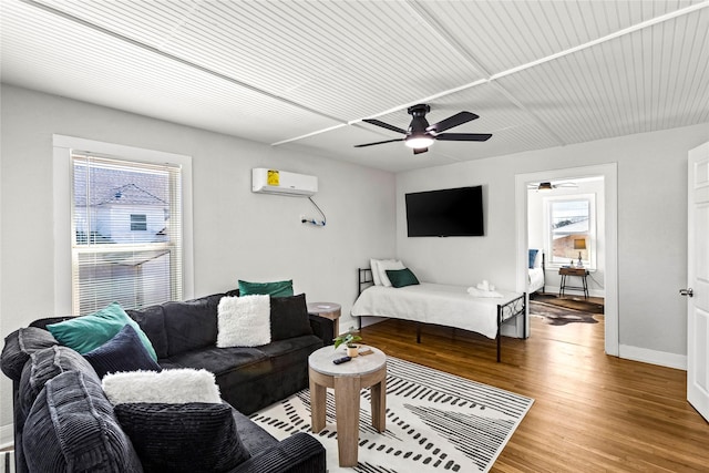 living area featuring ceiling fan, light wood finished floors, a wall mounted air conditioner, and a wealth of natural light