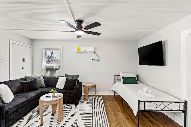 living room with baseboards, a wall mounted air conditioner, ceiling fan, and wood finished floors