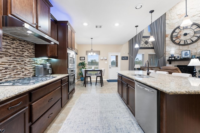 kitchen with visible vents, decorative backsplash, under cabinet range hood, a sink, and stainless steel appliances