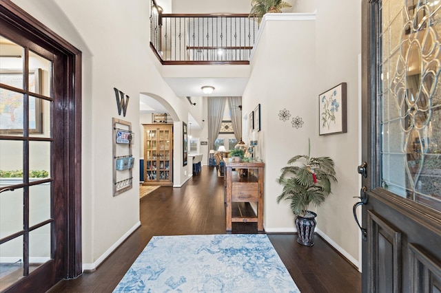 entryway featuring baseboards, a wealth of natural light, and hardwood / wood-style flooring