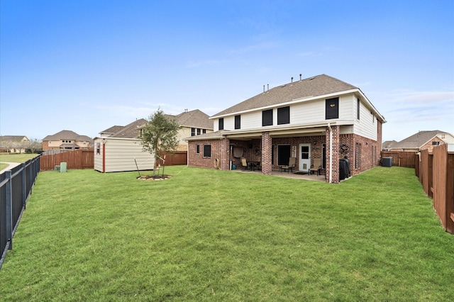 rear view of house with a fenced backyard, a lawn, and brick siding