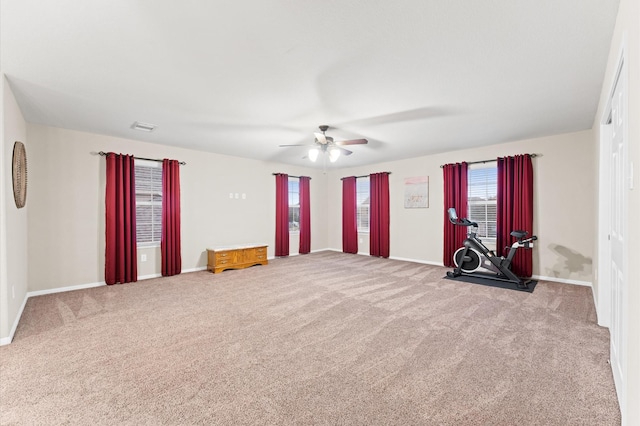 interior space with baseboards, ceiling fan, and carpet