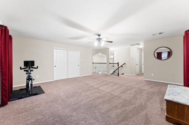 exercise area featuring carpet floors, baseboards, a ceiling fan, and visible vents