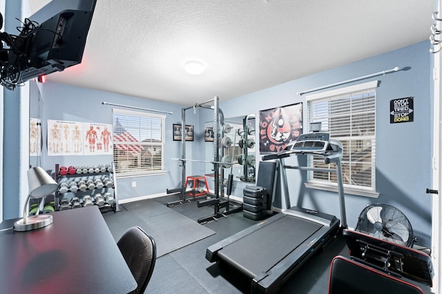 workout room featuring baseboards and a textured ceiling