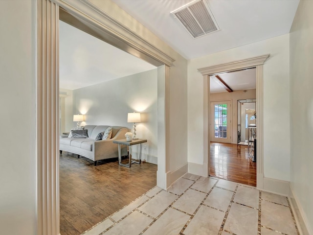 corridor with baseboards and wood finished floors