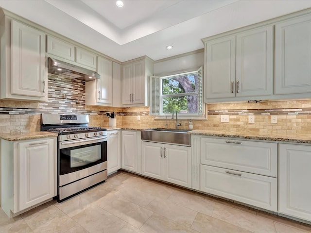 kitchen with stainless steel gas range oven, exhaust hood, a sink, backsplash, and recessed lighting
