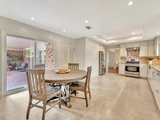 dining area with recessed lighting, baseboards, light tile patterned floors, and a tray ceiling