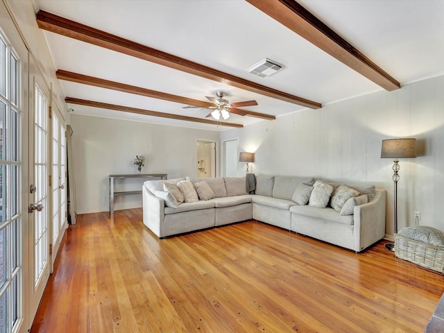 living area with beamed ceiling, light wood-style flooring, ceiling fan, and crown molding