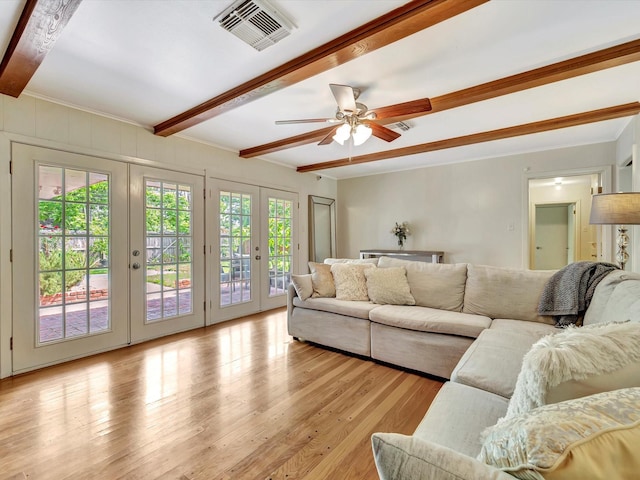 living room with beam ceiling, french doors, light wood-type flooring, a ceiling fan, and crown molding