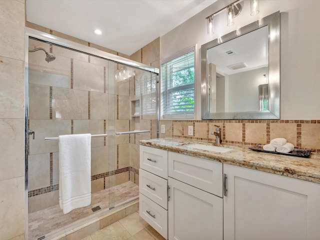 full bath with a stall shower, vanity, and decorative backsplash