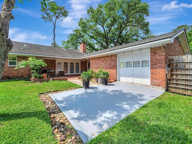 view of front of home with french doors, an attached garage, brick siding, and concrete driveway