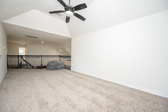 spare room with ceiling fan, visible vents, carpet floors, baseboards, and vaulted ceiling