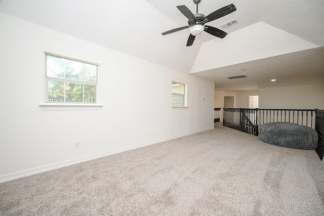 carpeted spare room featuring baseboards, a ceiling fan, lofted ceiling, and visible vents