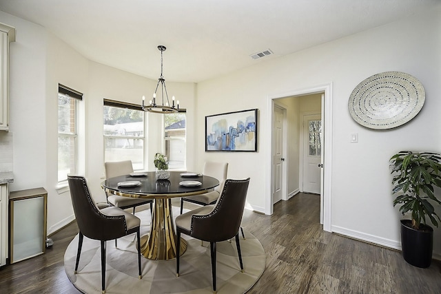dining area with dark wood-style flooring, baseboards, a chandelier, and visible vents