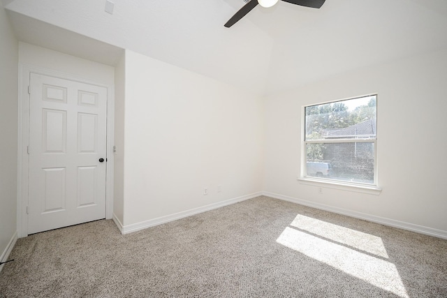 carpeted spare room featuring baseboards, ceiling fan, and lofted ceiling