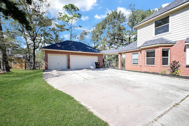 exterior space featuring a garage, a yard, driveway, and brick siding