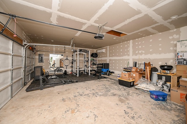 garage with an AC wall unit, a garage door opener, and electric panel
