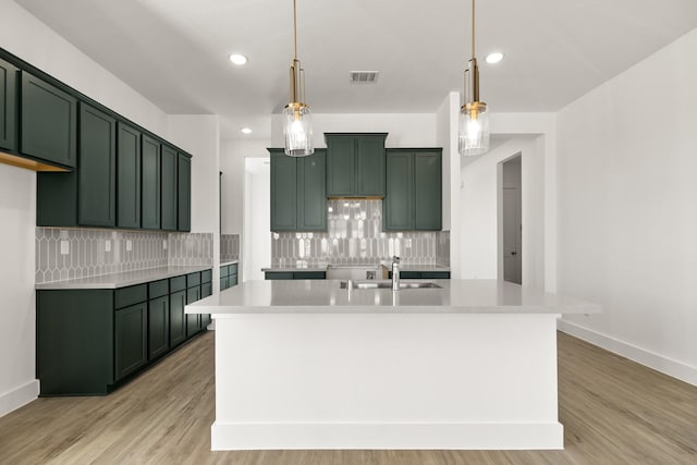 2219 Inglenook Grove Dr, Katy, TX 77493 - kitchen with green cabinets, a sink, tasteful backsplash, light countertops, and a center island with sink