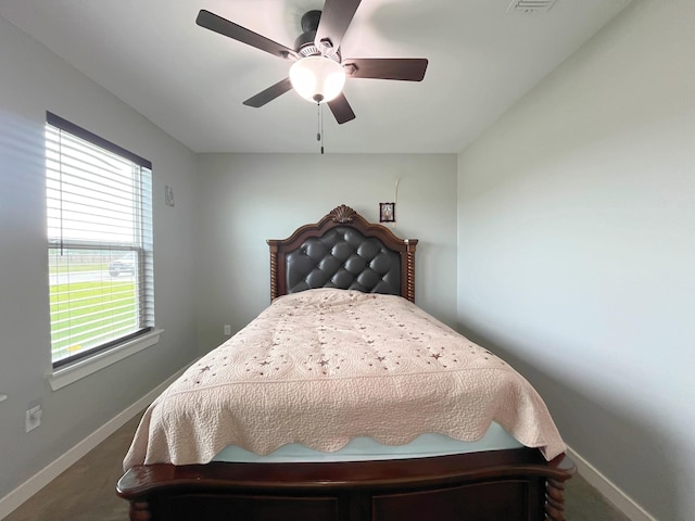 bedroom with baseboards, ceiling fan, and dark carpet