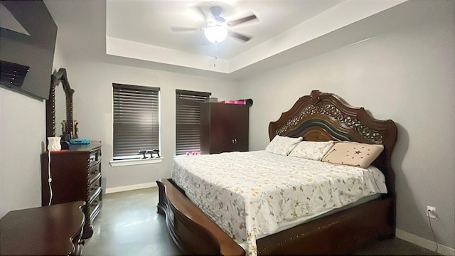 bedroom featuring baseboards, ceiling fan, and a raised ceiling