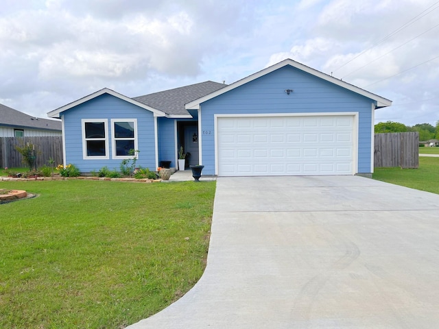 ranch-style house featuring an attached garage, fence, a front yard, and concrete driveway