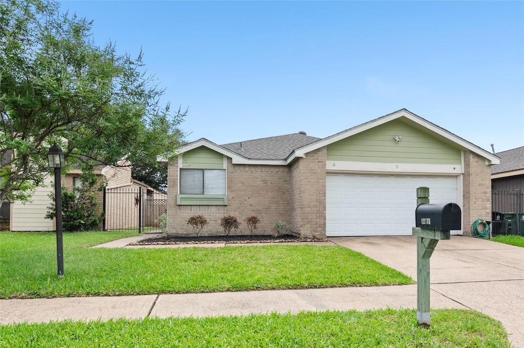 single story home featuring a garage, a front yard, driveway, and brick siding
