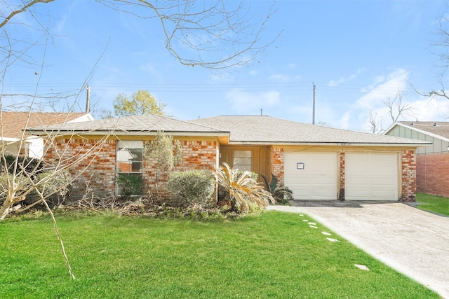 ranch-style home featuring concrete driveway, an attached garage, a front yard, and brick siding