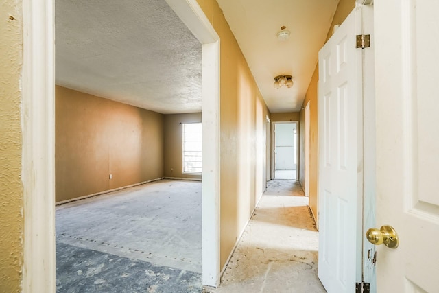 hall featuring a textured ceiling