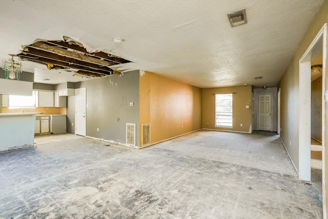 unfurnished living room featuring a textured ceiling and visible vents