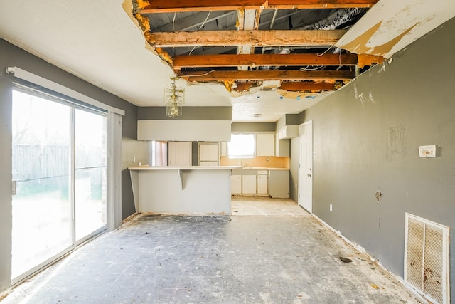 unfurnished living room featuring a sink and visible vents