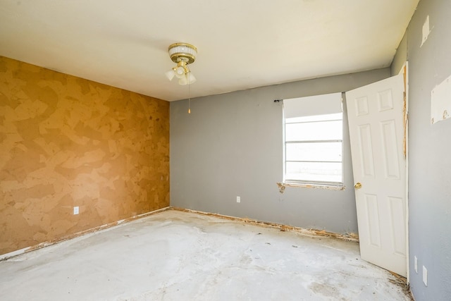 spare room featuring a ceiling fan and concrete floors
