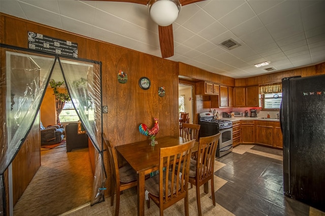 dining room with visible vents and wood walls