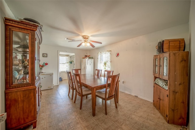dining space with light floors, ceiling fan, and visible vents