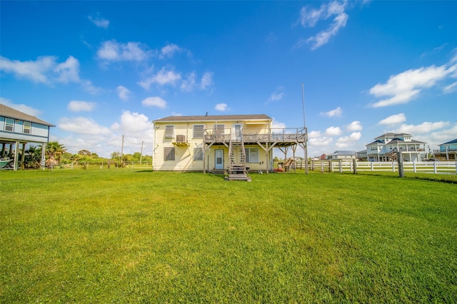 back of property featuring stairs, fence, a yard, and a deck