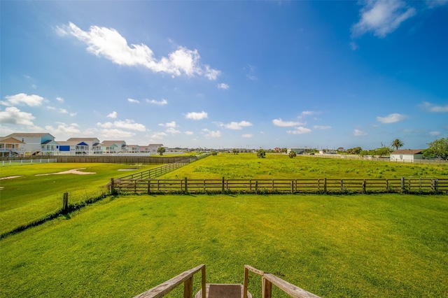 view of yard with fence and a rural view