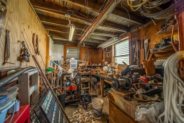 miscellaneous room featuring wood walls and a workshop area