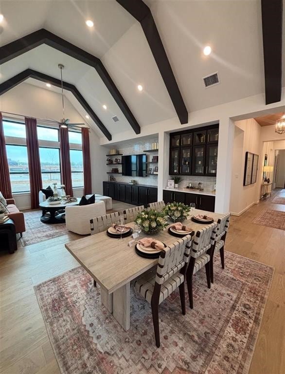 dining space featuring lofted ceiling with beams, recessed lighting, light wood-style flooring, and visible vents